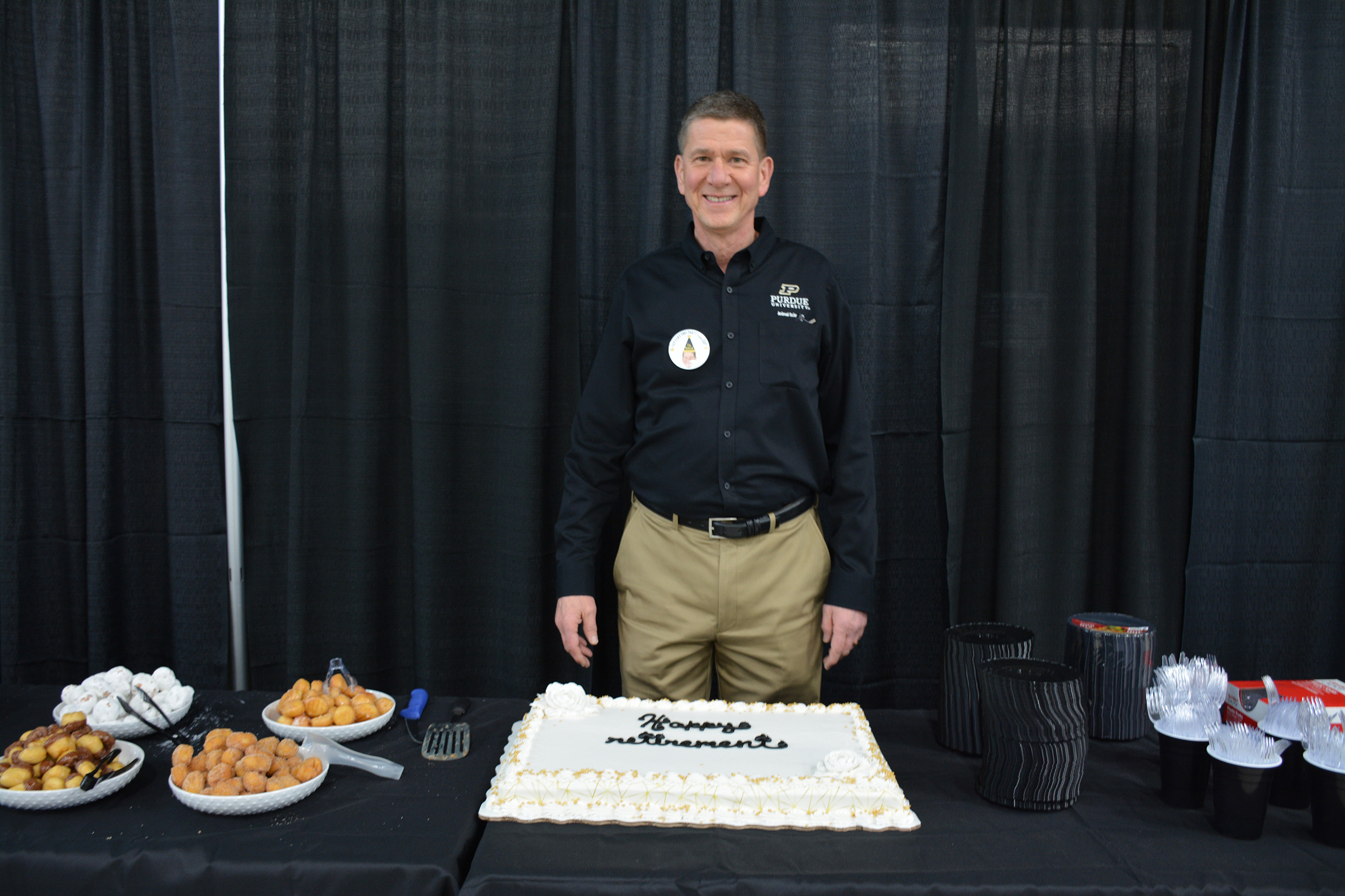 a man smiling with a cake