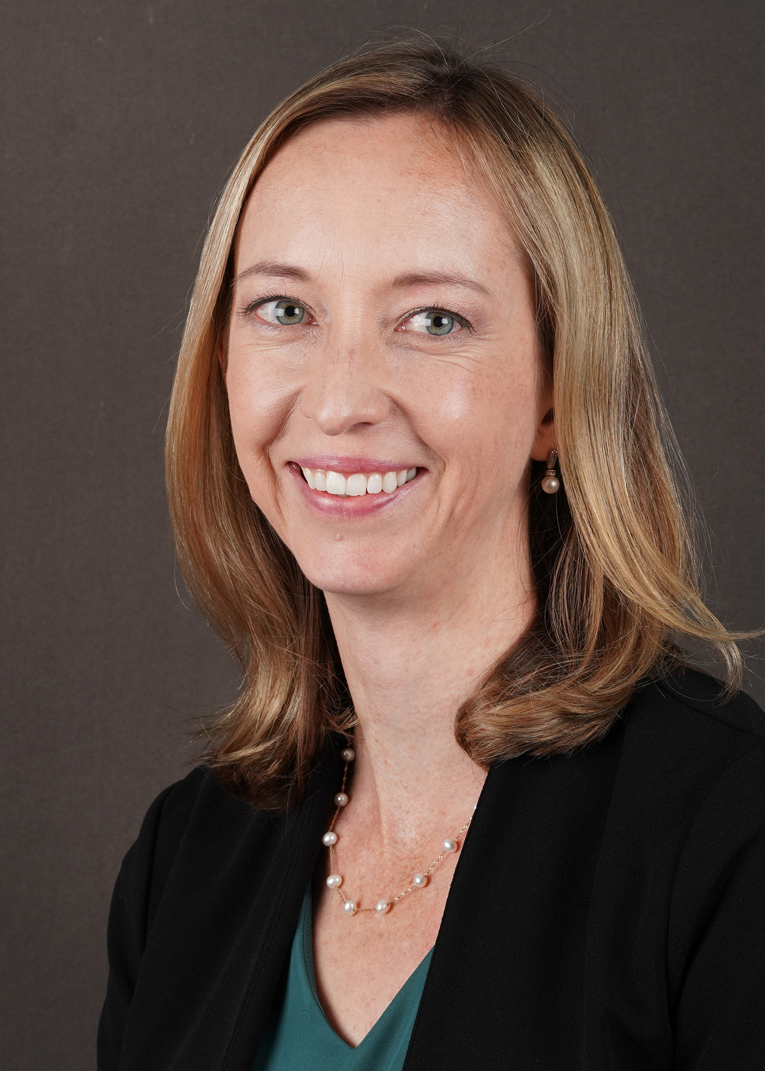 Headshot of Marisa Erasmus, assistant professor of animal sciences at Purdue University, smiling in front of a dark background.