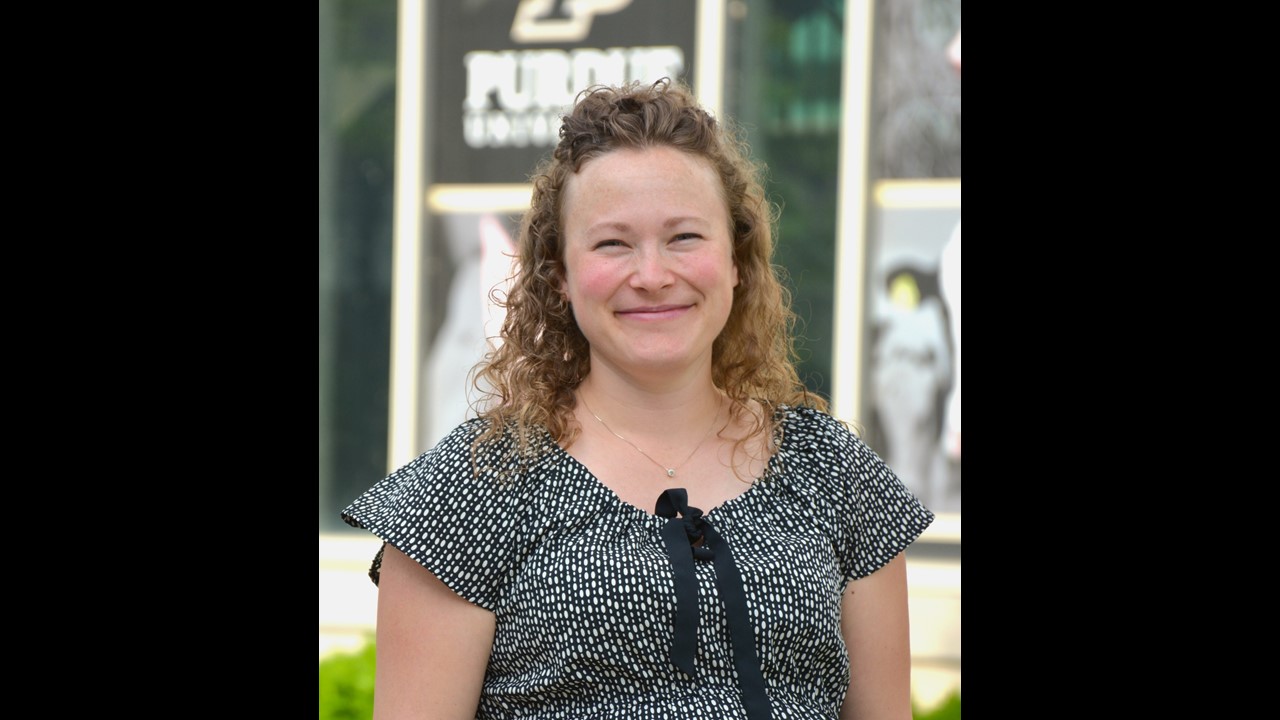 a woman smiling wearing a black and white shirt