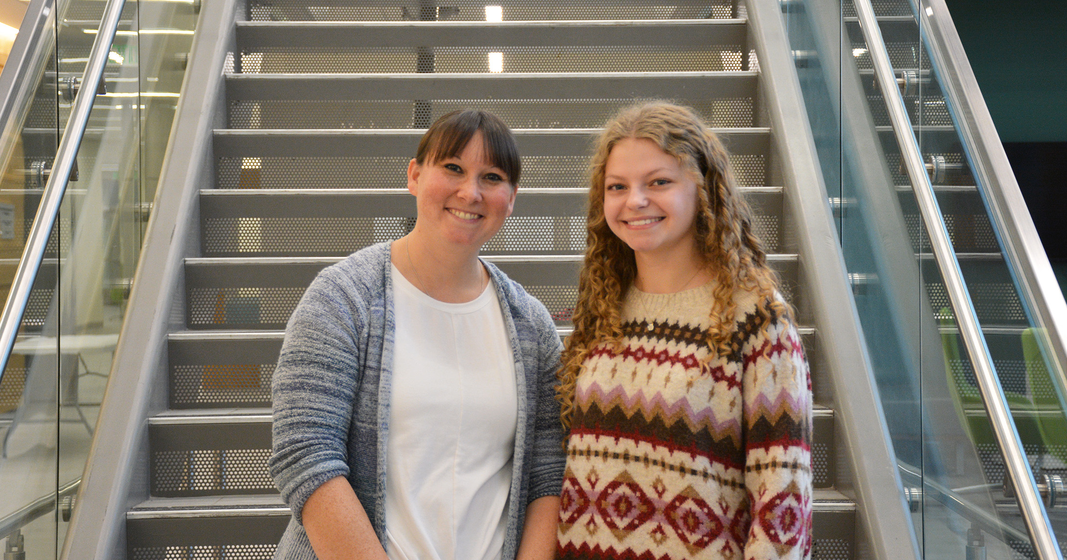 two women standing next to each other on a set of stairs