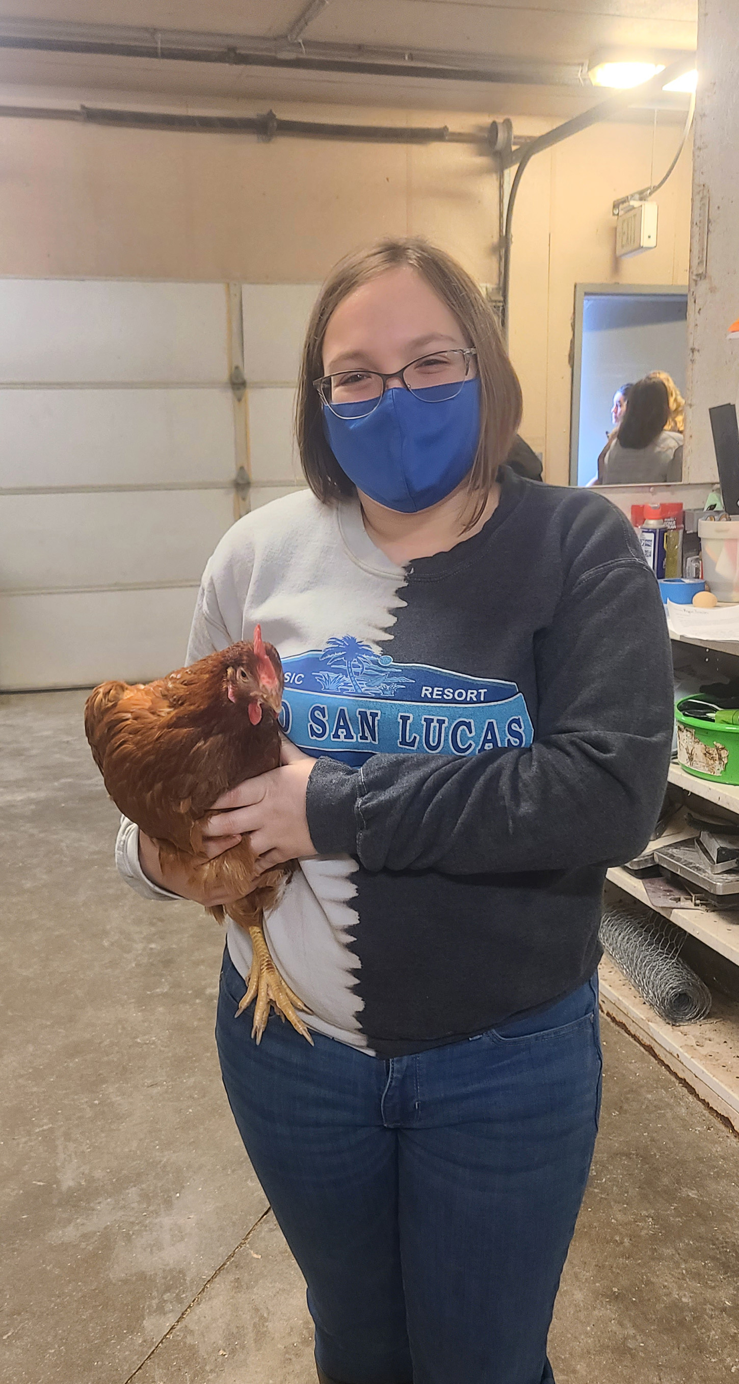 A student holds a chicken.
