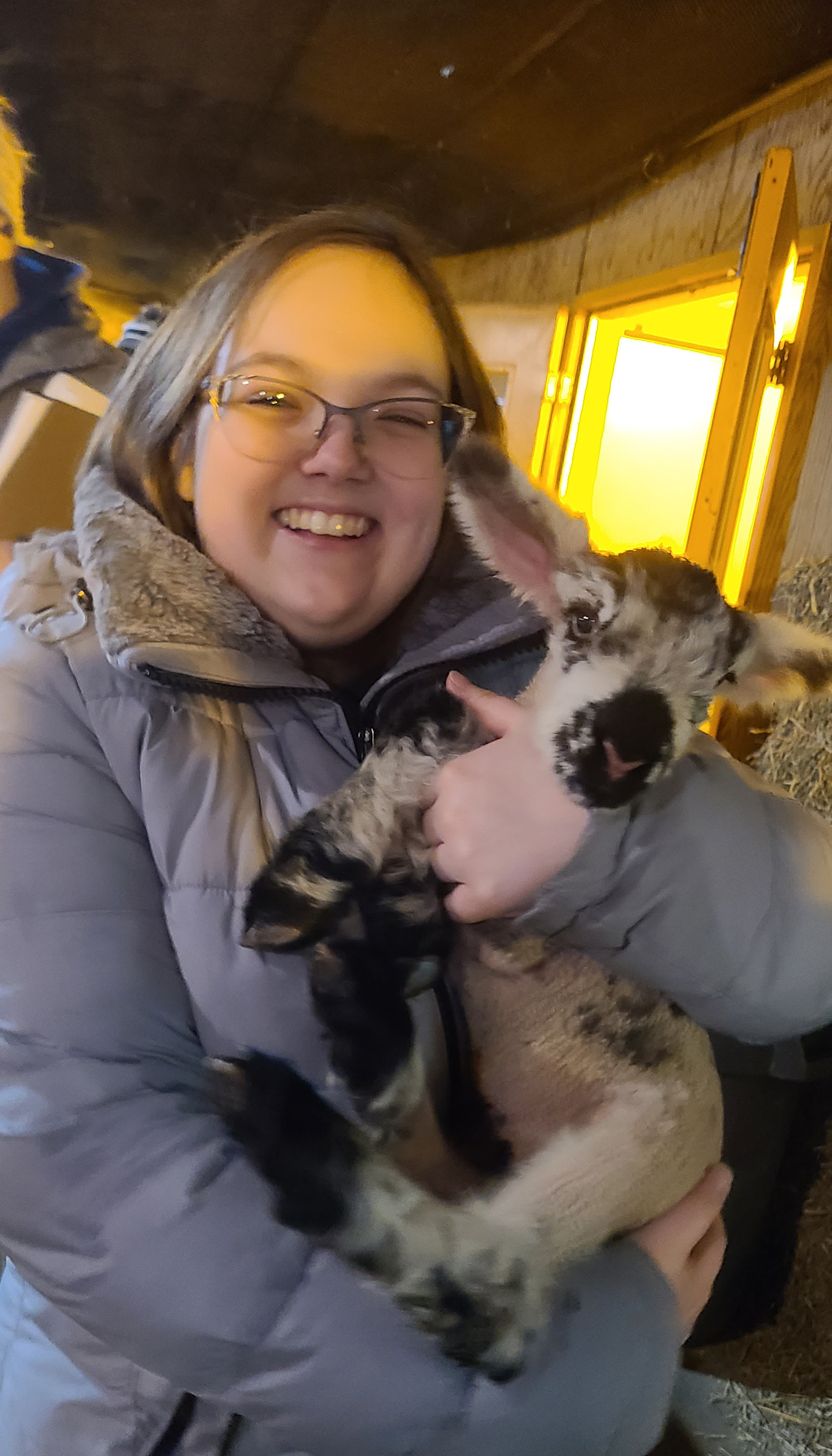 A student holds a lamb.