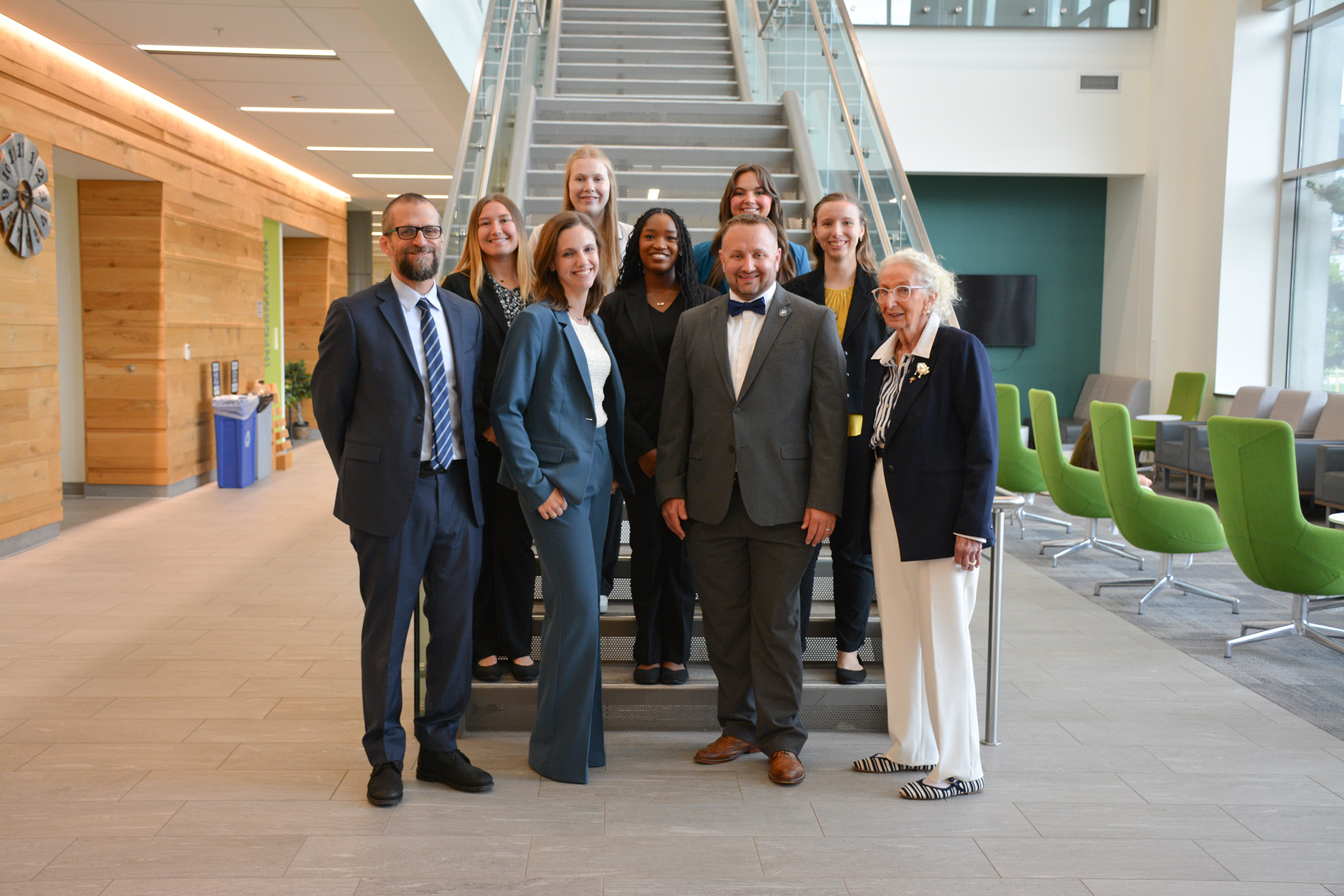 Department Head Paul Ebner stands on the stairs with students and alumni.