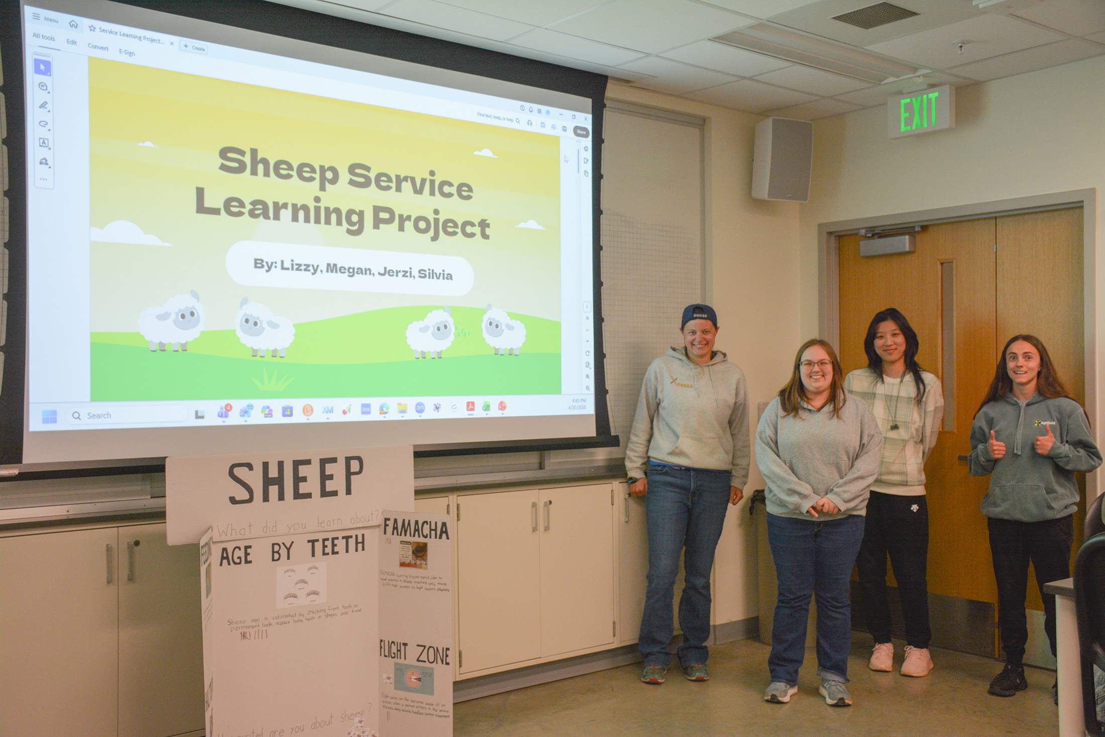 Students stand in front of a presentation that's titled "Shep Service Learning Project."