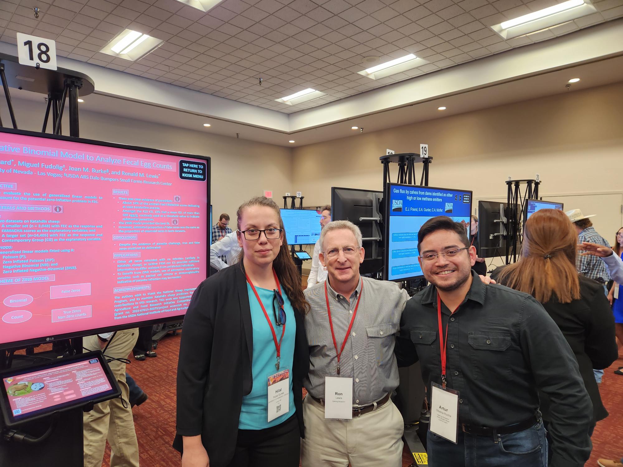 Artur Rocha stands with two individuals at a conference.