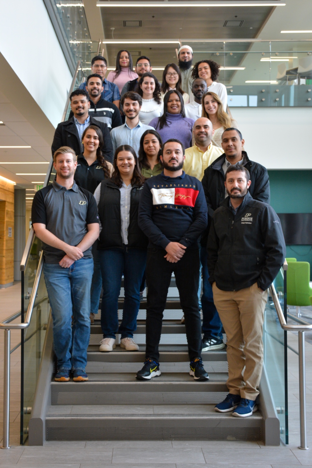 Members of Luiz Brito's lab stand together on a set of stairs.