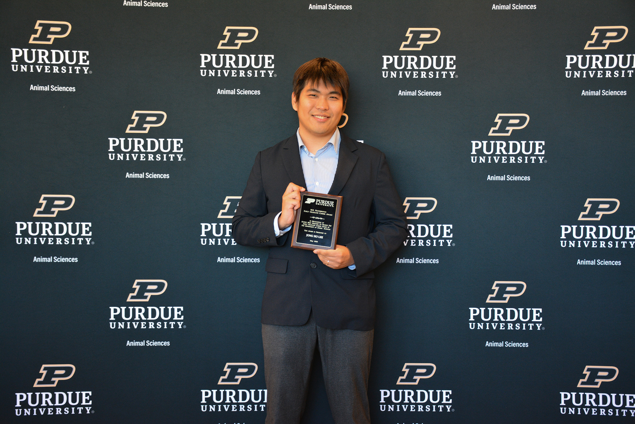Jong Ho Lee holds a plaque