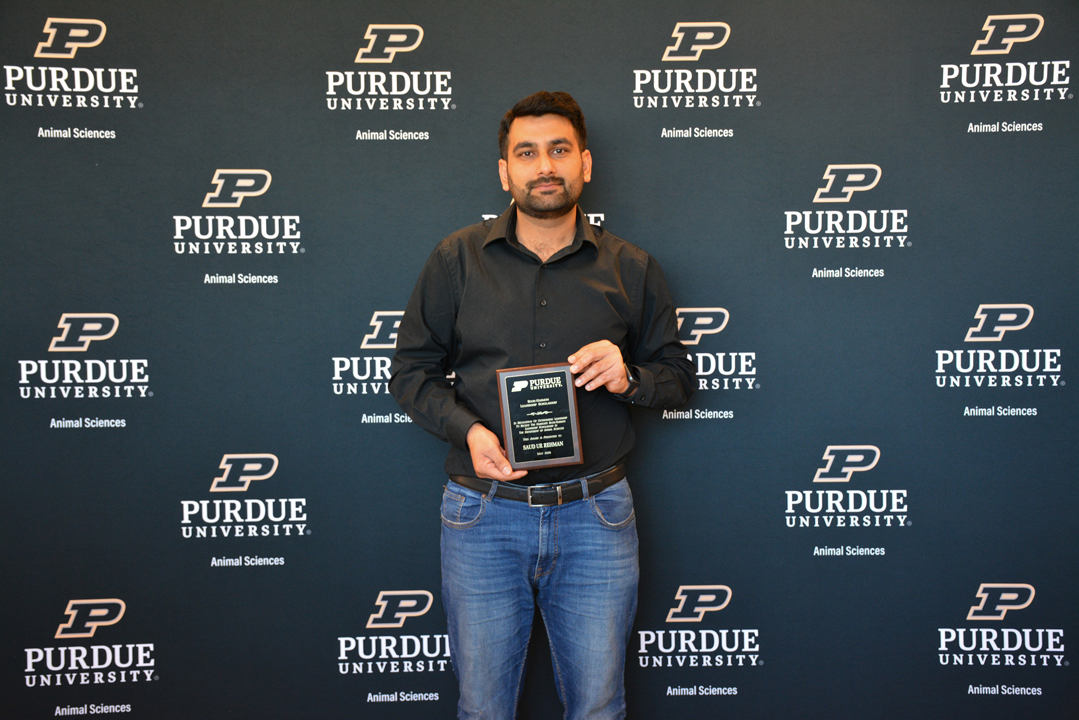 Saud Ur Rehman holds a plaque.