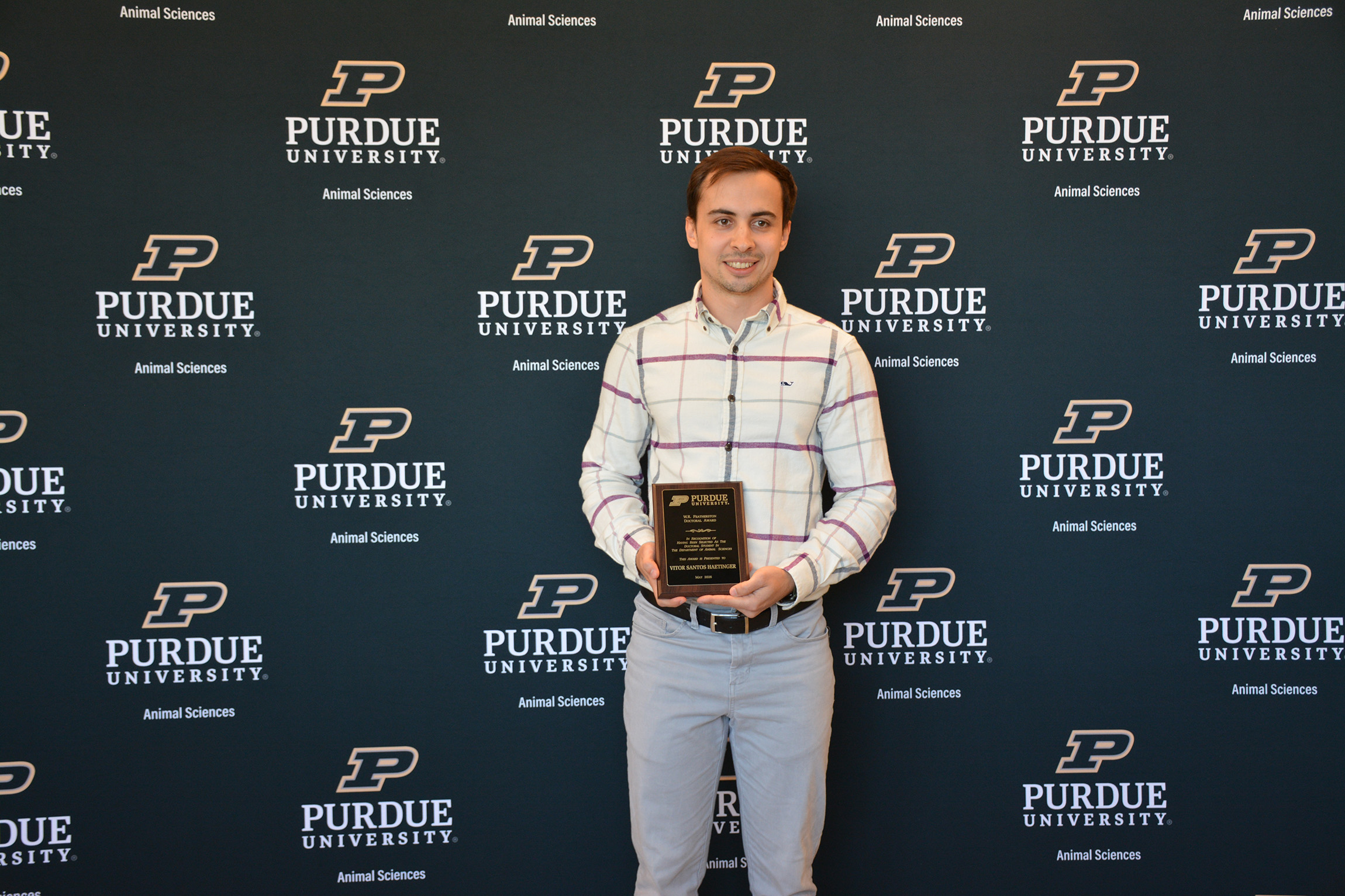 Vitor Santos Haetinger holds a plaque.