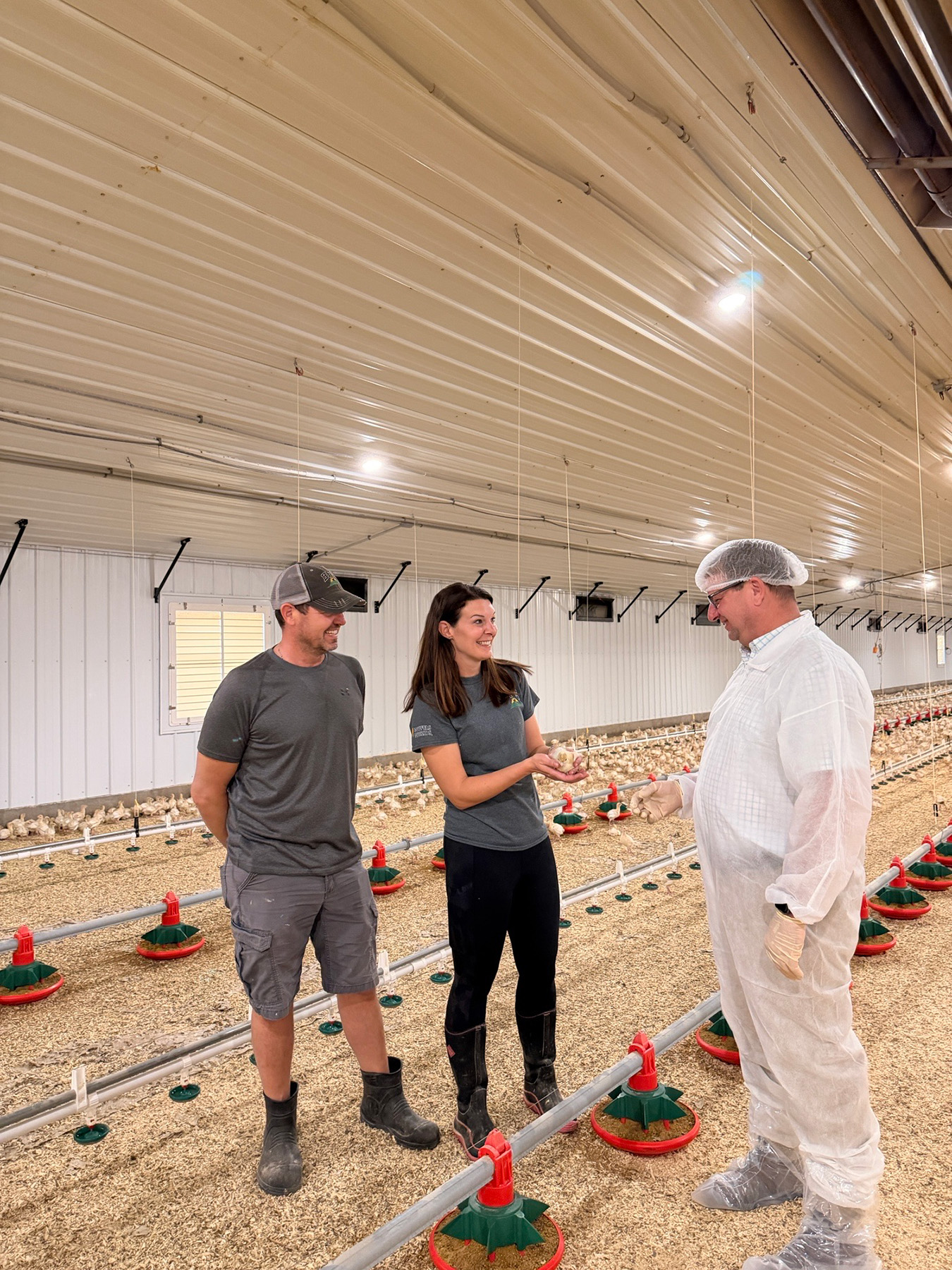 Ryan Schnell chats with turkey producers in a barn.