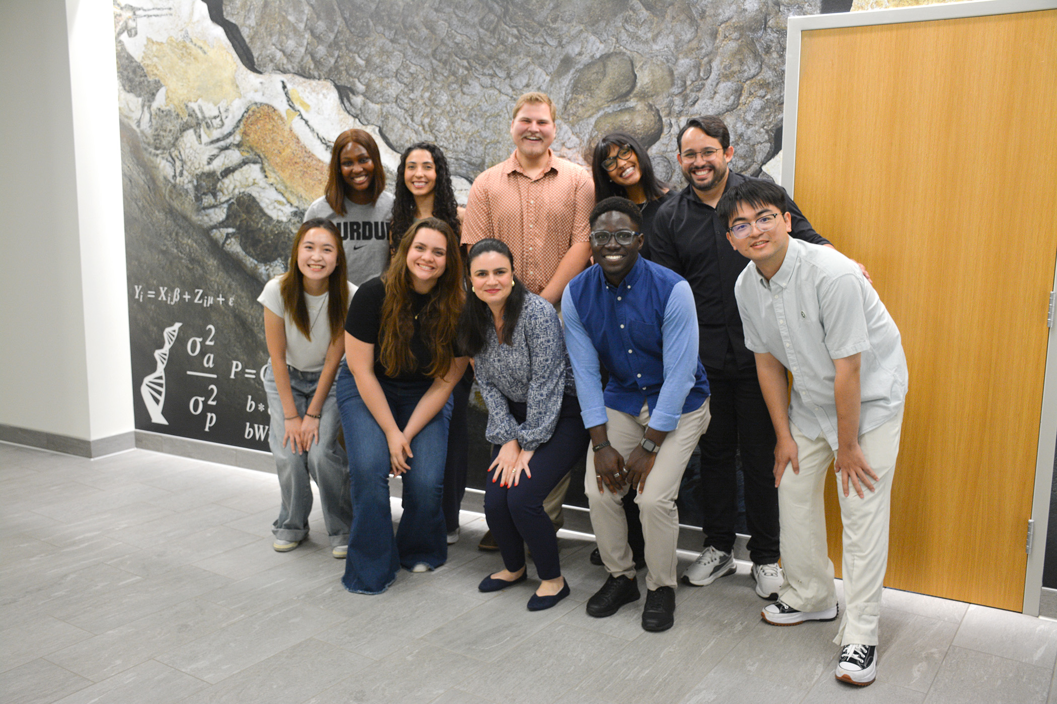 Members of Hinayah Rojas' lab stand together in front of a mural.