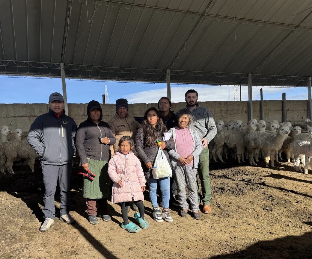 Luiz Brito stands with livestock producers and their family at an alpaca farm