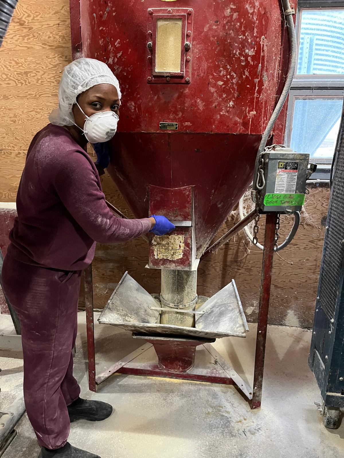 Victoria Uyanga works with poultry feed at a research facility.