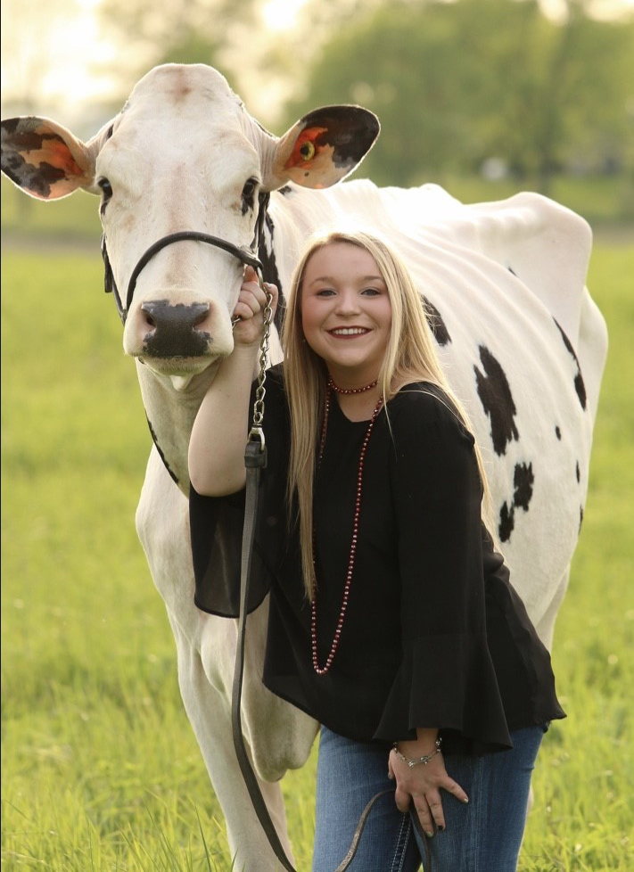 Caitlyn Cox poses with a cow