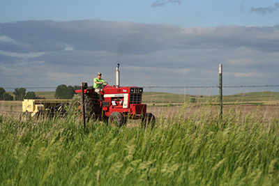 Janke driving a tractor, while working with Zach Lowe on a planting in Kansas during the summer of 2009.