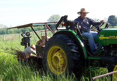 Seifert drives a tractor while planting trees in 2021