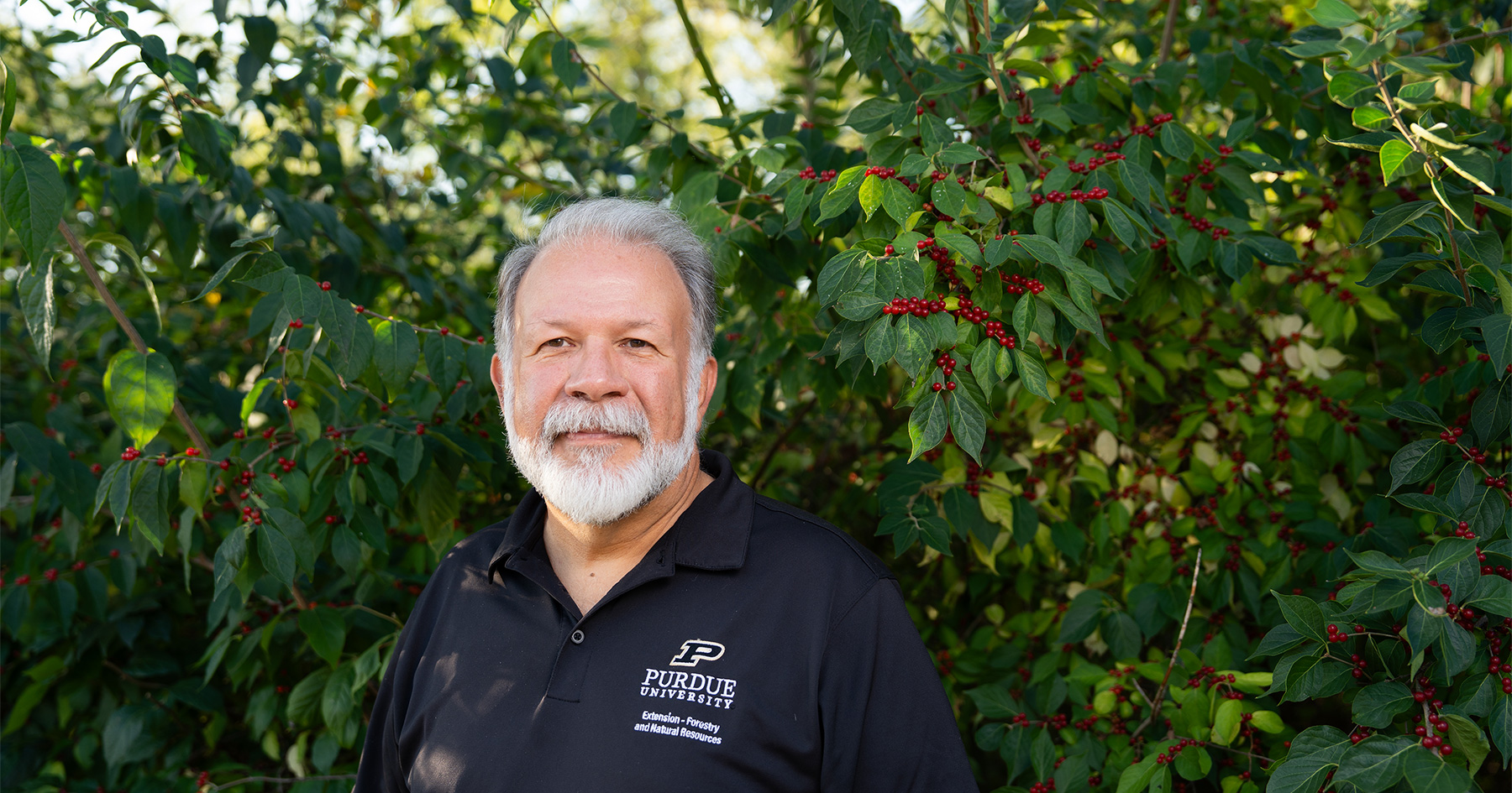 Forest pest specialist Lenny Farlee standing in front of a bush.
