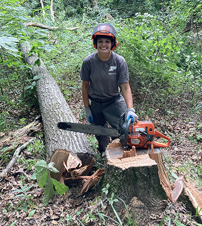 Mikaela Agresta with a heavily leaning red oak she felled at SEPAC.