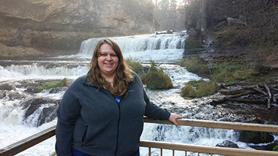 Geriann Albers stands in front of a waterfall