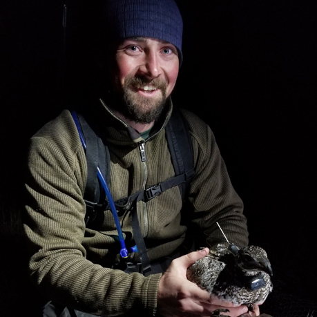 Scott Allaire holding duck at night.