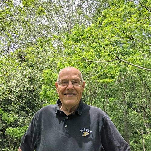 Walt Beineke stands next to one of the space sycamores he planted on his property. 