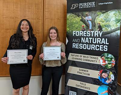 Amanda Herbert and Summer Brown pose with their certificates for the L. David Mech Distinguished Undergraduate Research Award