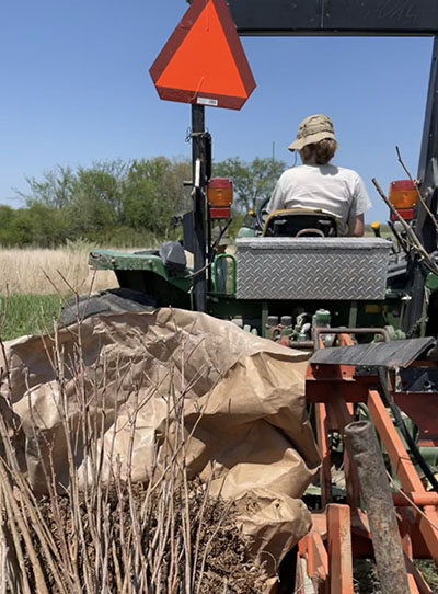 Summer Brown on a tractor planting trees 