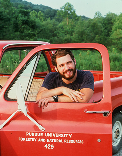 Dave Case standing next to a Purdue FNR truck, doing research on Naval Surface Warfare Center Crane