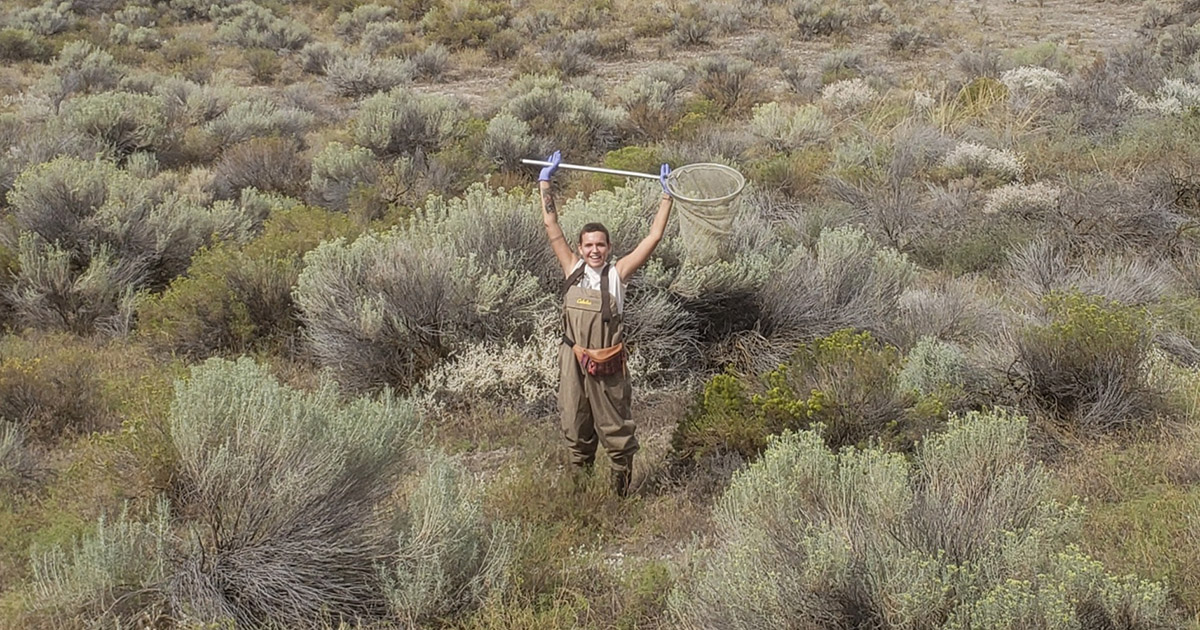 Master's student Erin Christian stands in a field