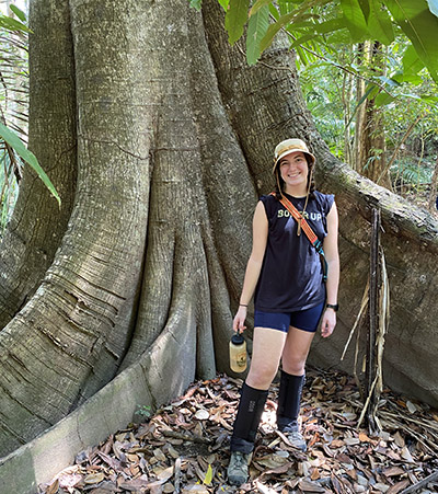 Leah Griffin standing in front of a massive fig tree of tropical dry forest at Curú. 