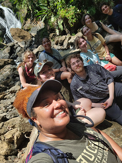 Megan Gunn and students from the 2026 Costa Rica study abroad trip take a selfie in front of a waterfall.