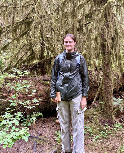 Brett Cox stands in a forested area. 