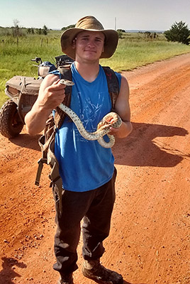 Dr. Zackary Delisle holds a bull snake 