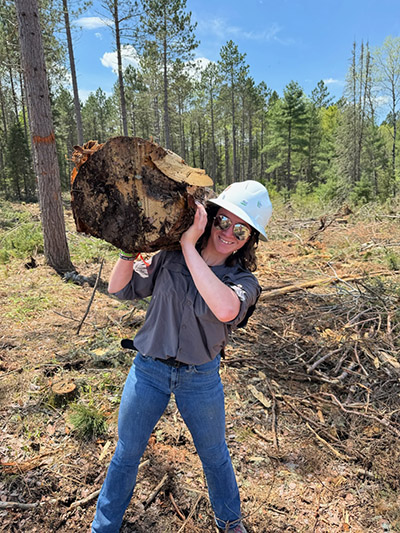 Sophia DeMoss holds a log