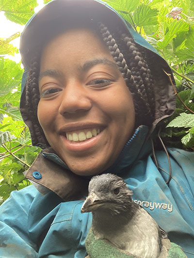 Gabby Dennis holding a rhinoceros auklet chick