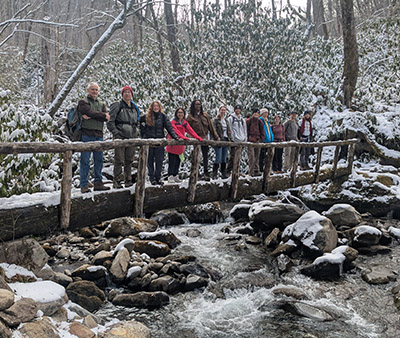 Disturbance Ecology spring break 2026 group stands on a snow-covered bridge