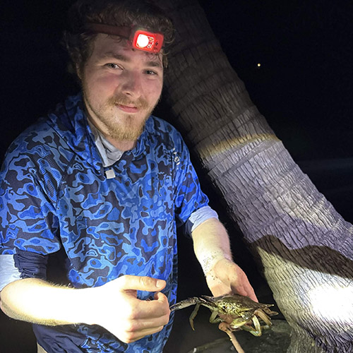 Liam Doski holds a bird; Doski holds a crab; Doski looks through binoculars