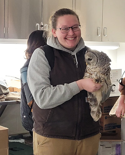 Alex Dudley holds an owl at a TWS event at the Cook County Forest Preserve.