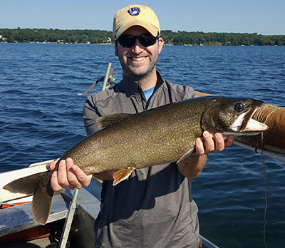 Zach Feiner holds a big green lake trout.