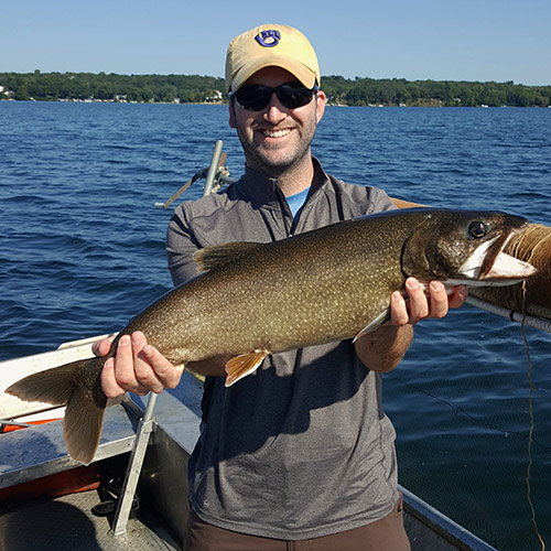 Zach Feiner holds a striped bass; Feiner holds a black crappie; Feiner holds his Outstanding Young Alumni Award plaque