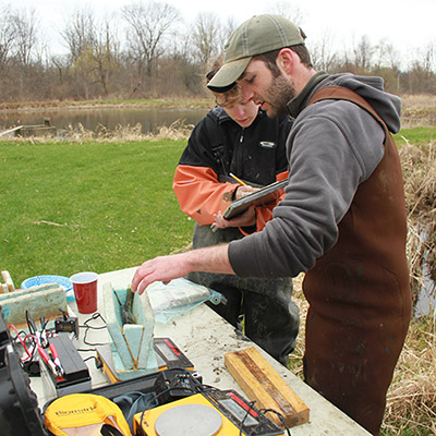 Zach Feiner doing fieldwork alongside a student