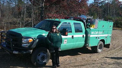Kristin Floress stands next to a U.S. Forest Service truck