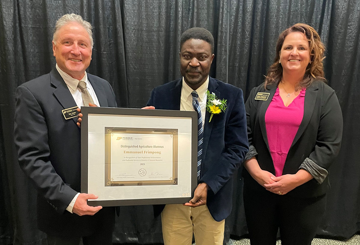 Dr. Emmanuel Frimpong receives his Distinguished Ag Alumni Award from Ken Foster, Interim Dean of Agriculture, and Danica Kirkpatrick, executive director of the Purdue Agricultural Alumni Association.
