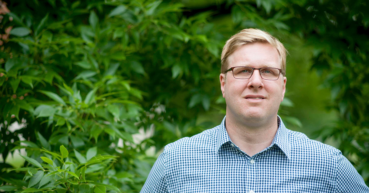 Dr. Matt Ginzel stands in front of a forested area