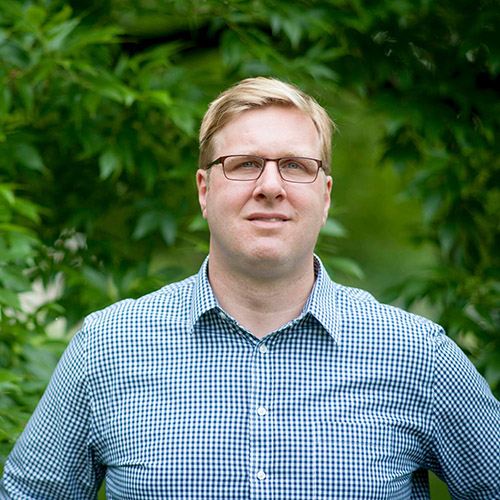 Dr. Matt Ginzel stands in front of a forested area