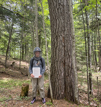 Leah Griffin holds a clipboard in the forest