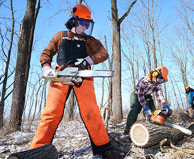 Leah Griffin holds a chainsaw