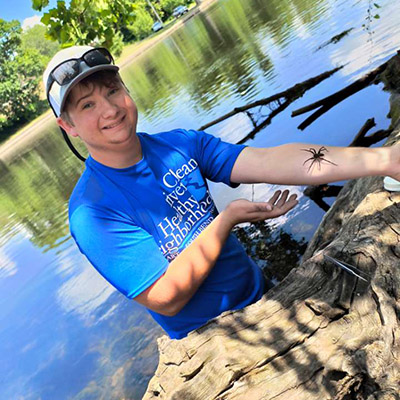 Haas holds a very large fishing spider he picked up off a log