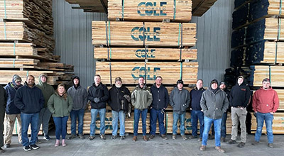 Hardwood University students stand in front of air dried hardwood lumber at Cole Hardwood in Logansport, Indiana