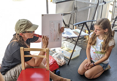 Eva Haviarova demonstrates the strength of wood to a child at the Woods on Wheels exhibit at the Hoosier Hardwood Festival in 2023. 